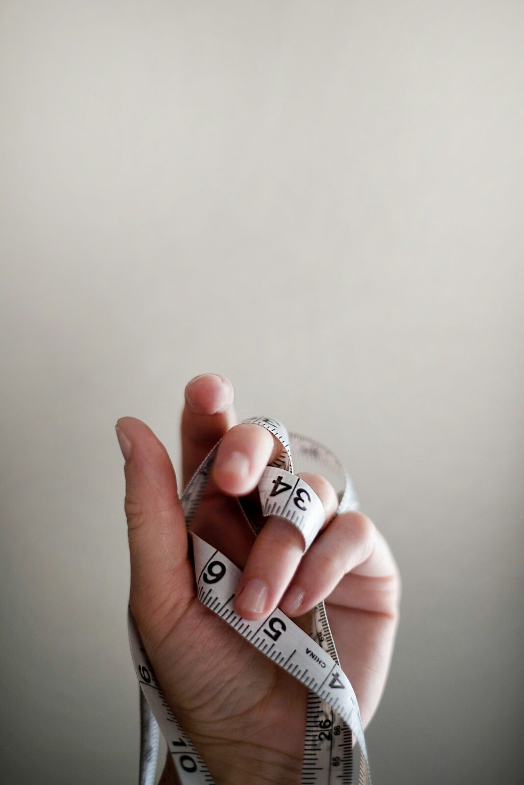 Close-up of a hand holding a tailor's measuring tape